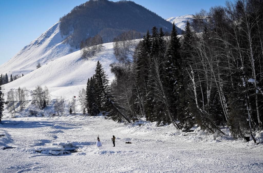 2024年2月5日，兩名游客在新疆阿勒泰地區(qū)布爾津縣禾木村拍照。新華社記者 馬鍇 攝