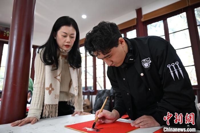 1月20日，外籍留學(xué)生在西泠印社社員李硯指導(dǎo)下寫福。當(dāng)日，來(lái)自巴西、馬來(lái)西亞、加納、哈薩克斯坦的外籍留學(xué)生在浙江杭州西泠印社體驗(yàn)福貼、春聯(lián)和篆刻，感受古老的中國(guó)傳統(tǒng)文化。中新社記者 王剛 攝