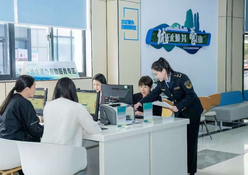 工作人員指導(dǎo)企業(yè)一次性完成信息填報(bào)。圖片來源：浙江衢州市市場(chǎng)監(jiān)督管理局