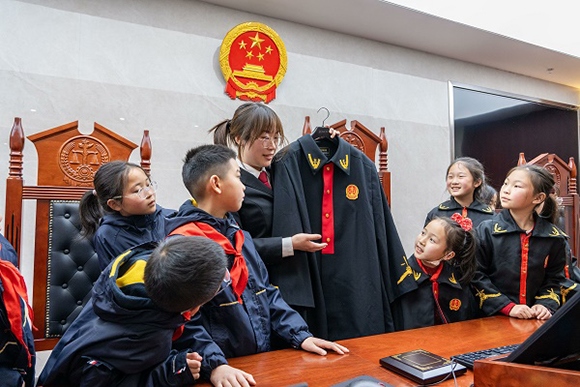 圖②：干警向同學(xué)們介紹法袍。