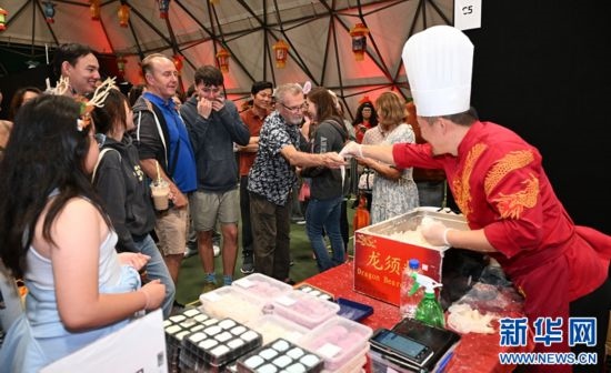 圖為游客在燈節(jié)現(xiàn)場購買小吃。（圖片由奧克蘭中國文化中心提供）