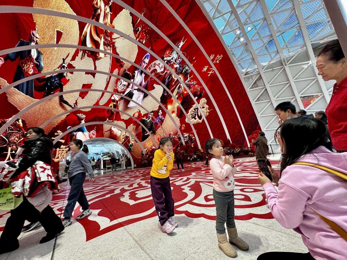乙巳蛇年春節(jié)期間，影迷在《哪吒之魔童鬧?！肪薹?bào)前拍照打卡。