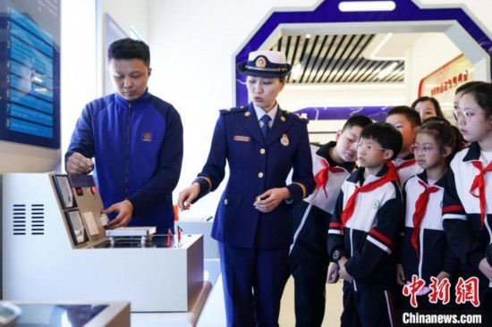 圖為學生們參觀道里區(qū)消防救援大隊消防科普體驗館內(nèi)電器火災演示實驗臺。中新社記者 趙宇航 攝