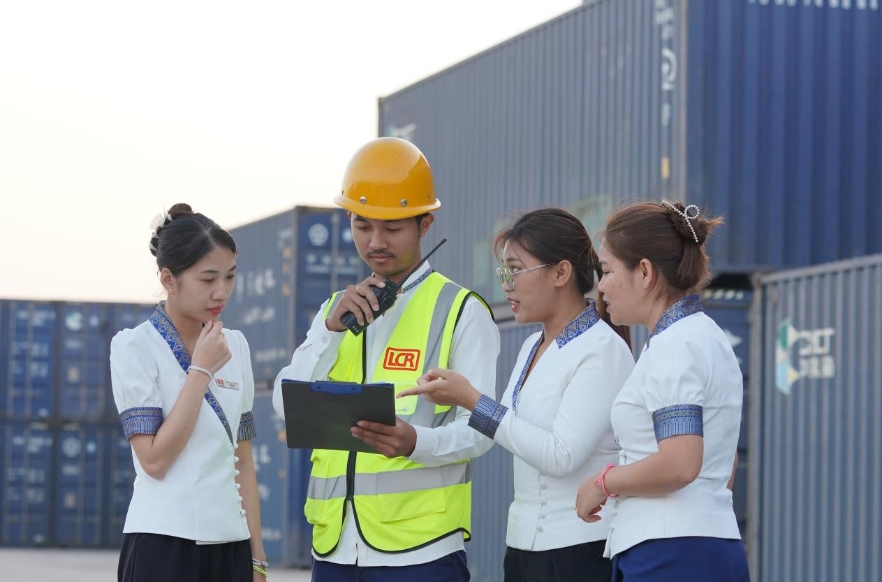 萬(wàn)象南站貨運(yùn)值班員陳尼啦（左一）與同事在一起討論工作。老中鐵路有限公司供圖