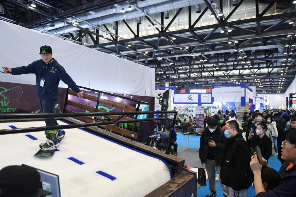 2023年2月11日，參觀者在展會(huì)上了解一款模擬滑雪設(shè)備。當(dāng)日，2023亞洲運(yùn)動(dòng)用品與時(shí)尚展在國家會(huì)議中心拉開帷幕。新華社記者 張晨霖 攝