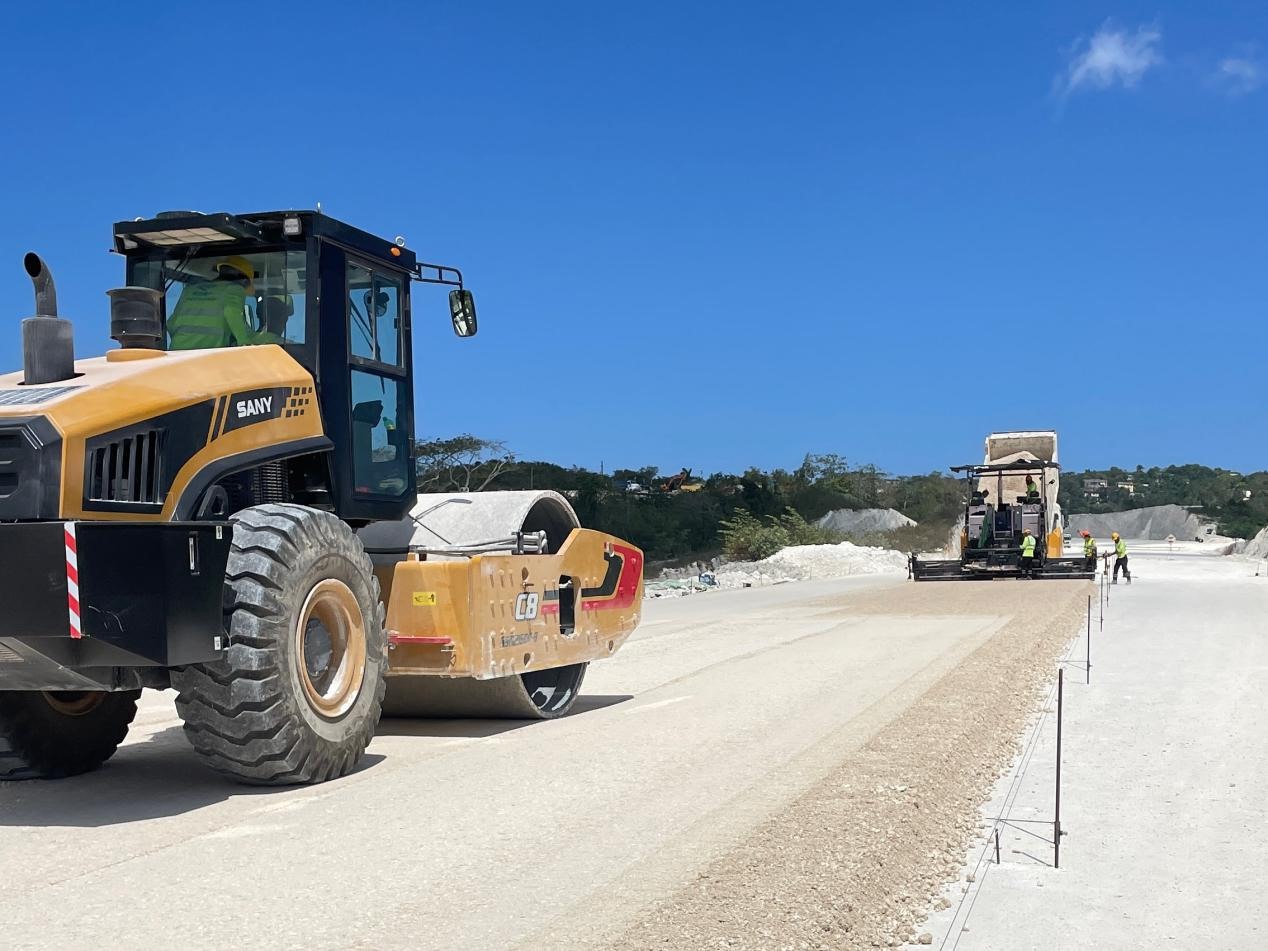 圖為中企承建的牙買加蒙特哥貝繞城路項(xiàng)目基層試驗(yàn)段正在進(jìn)行攤鋪和碾壓施工，相關(guān)施工工作已于日前順利完成。中國(guó)港灣美洲區(qū)域公司供圖