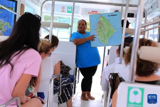 3月15日，一名導(dǎo)游在游艇上為游客介紹塞舌爾拉迪格島。新華社記者 董江輝 攝