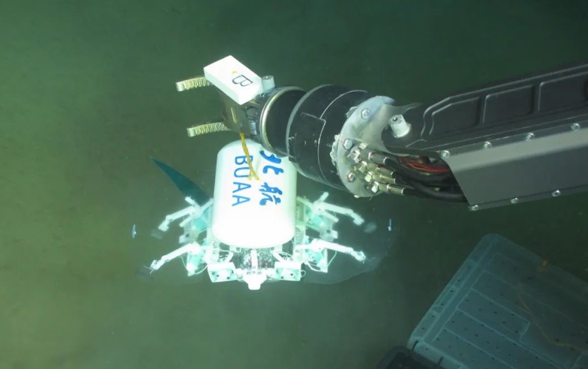 科研人員利用機(jī)械臂將北航深海小型機(jī)器人投于馬里亞納海溝。校方供圖