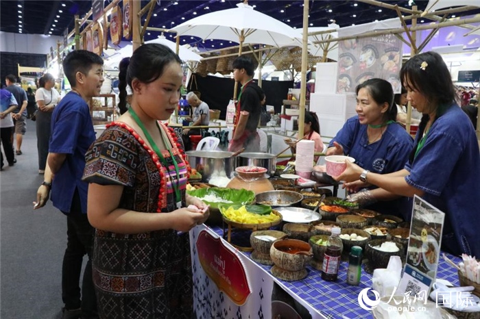 游客在攤位前購(gòu)買特色美食。朱瀟逸攝