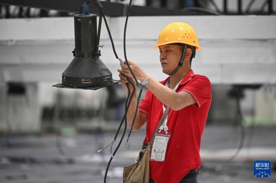 4月4日，工作人員在海南國(guó)際會(huì)展中心內(nèi)布設(shè)燈光。