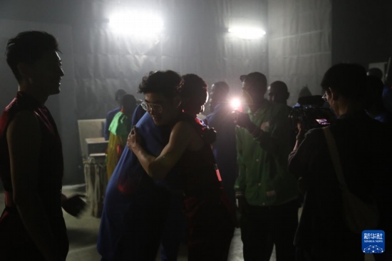 4月10日，在塞內(nèi)加爾首都達喀爾的國家大劇院，中央音樂學院進擊打擊樂團成員與塞內(nèi)加爾杜杜·恩迪亞耶·羅斯打擊樂團成員在演出后臺擁抱。新華社記者 司源 攝