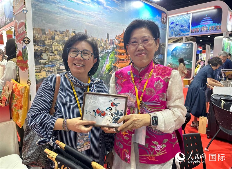 中國(guó)“大冶刺繡”傳承人劉小紅（右）參加泰國(guó)國(guó)際旅游展，向觀眾介紹中國(guó)非遺刺繡針法。人民網(wǎng)記者 簡(jiǎn)承淵攝