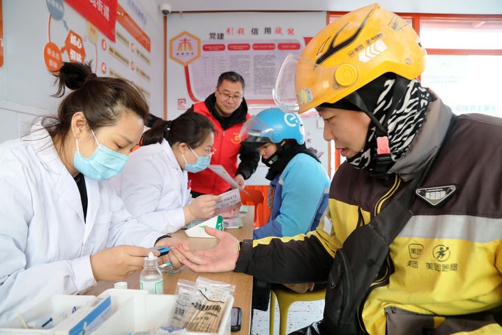 2025年3月5日，志愿者在山東省棗莊市市中區(qū)一工會(huì)驛站為外賣(mài)員免費(fèi)測(cè)量血糖。新華社發(fā)（王海楠攝）