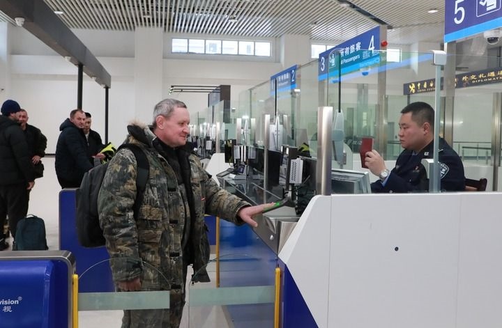 2024年12月10日，在黑河公路口岸旅檢大廳，黑河出入境邊防檢查站民警為首班次客車入境旅客辦理邊檢通關手續(xù)。當日，中國黑河公路口岸—俄羅斯卡尼庫爾干公路口岸旅客運輸正式開通。新華社發(fā)（劉松攝）