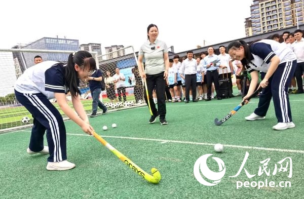 陳朝霞（中）指導(dǎo)學(xué)生體驗(yàn)曲棍球。 人民網(wǎng)記者 楊磊攝
