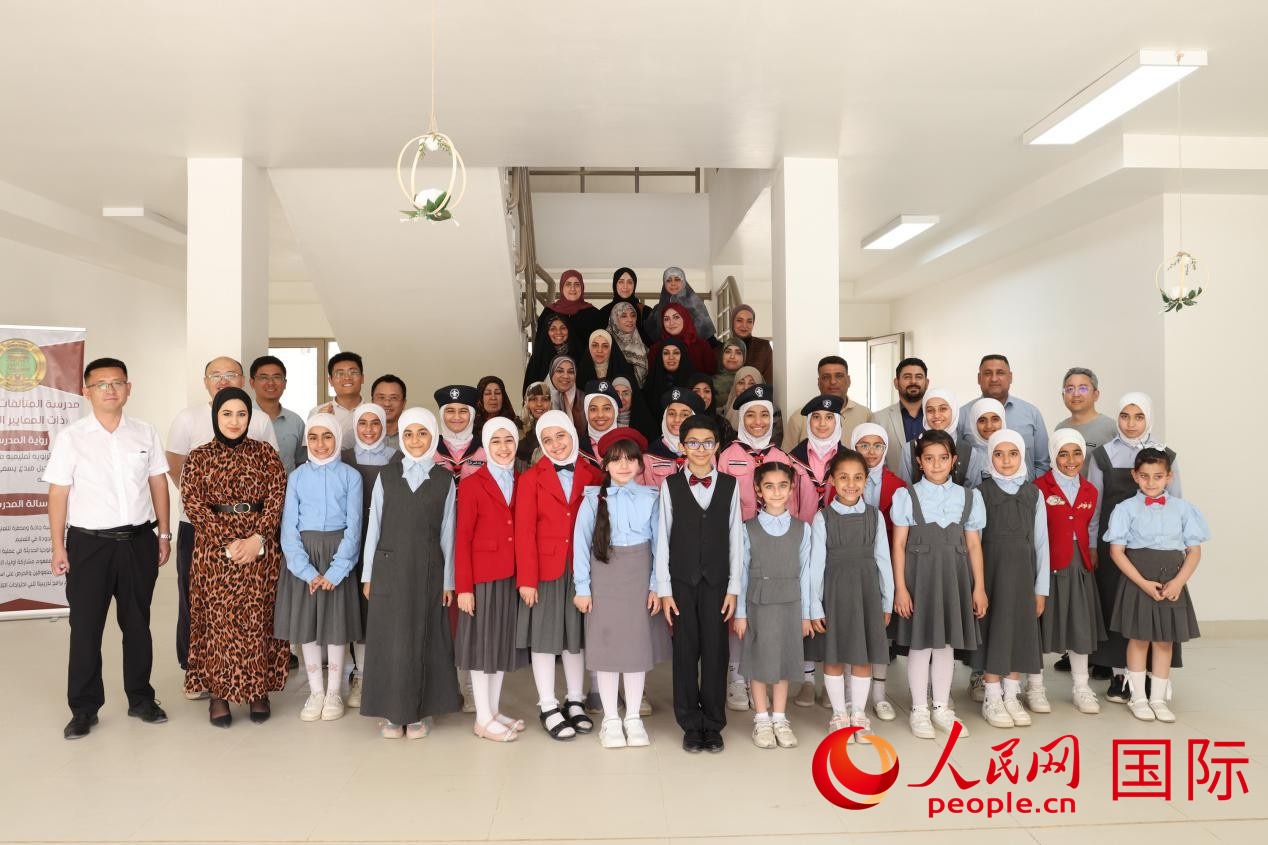 中國電建員工與阿爾穆塔?阿里卡特國際學(xué)校的師生及政府官員等合影。人民網(wǎng)記者 薛丹攝