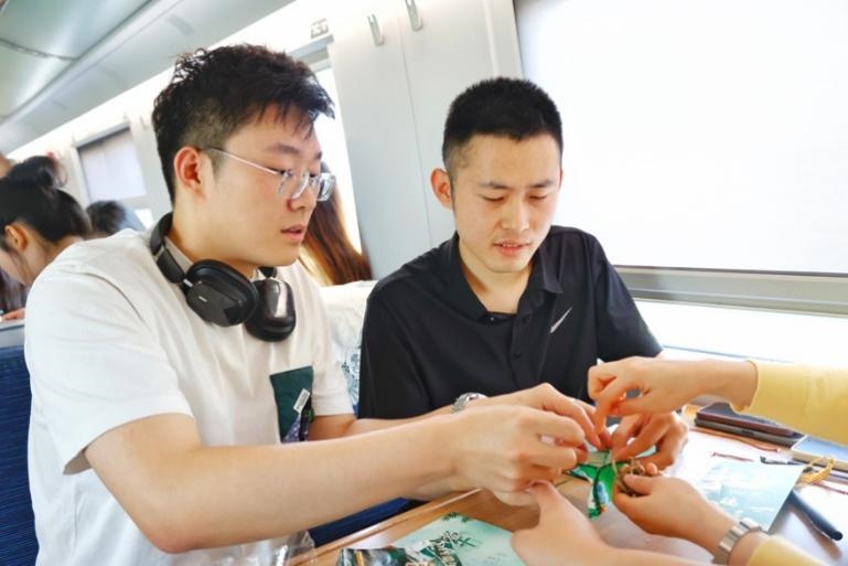 G232次旅客親手制作端午荷包和五彩繩。王磊攝