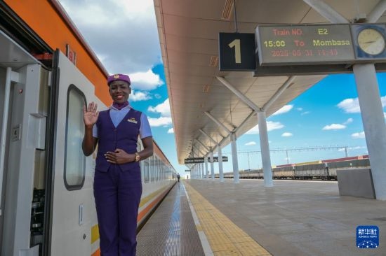 5月31日，在蒙內(nèi)鐵路內(nèi)羅畢站，一名乘務(wù)員在即將開往蒙巴薩的E2次列車旁等候乘客。新華社記者 楊光 攝