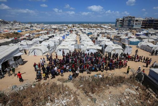 5月28日，人們在加沙城西部的沙提難民營等待領(lǐng)取救助食物。新華社發(fā)（里澤克·阿卜杜勒賈瓦德攝）