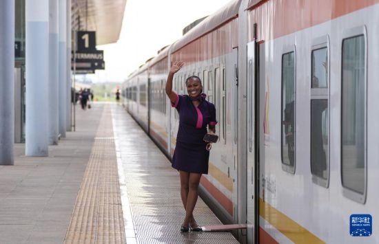 5月31日，在蒙內(nèi)鐵路內(nèi)羅畢站，一名乘務(wù)員在即將開往蒙巴薩的E2次列車旁等候乘客。新華社記者 李亞輝 攝