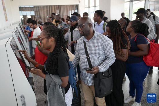 5月31日，在蒙內(nèi)鐵路內(nèi)羅畢站，乘客在自助取票機(jī)前排隊(duì)取票。新華社記者 楊光 攝