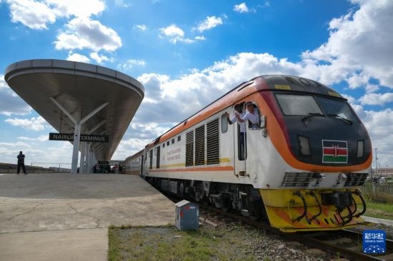 5月31日，在蒙內(nèi)鐵路內(nèi)羅畢站，機(jī)車駕駛員蔣立平（右）和博爾在即將開往蒙巴薩的E2次列車上揮手致意。新華社記者 楊光 攝